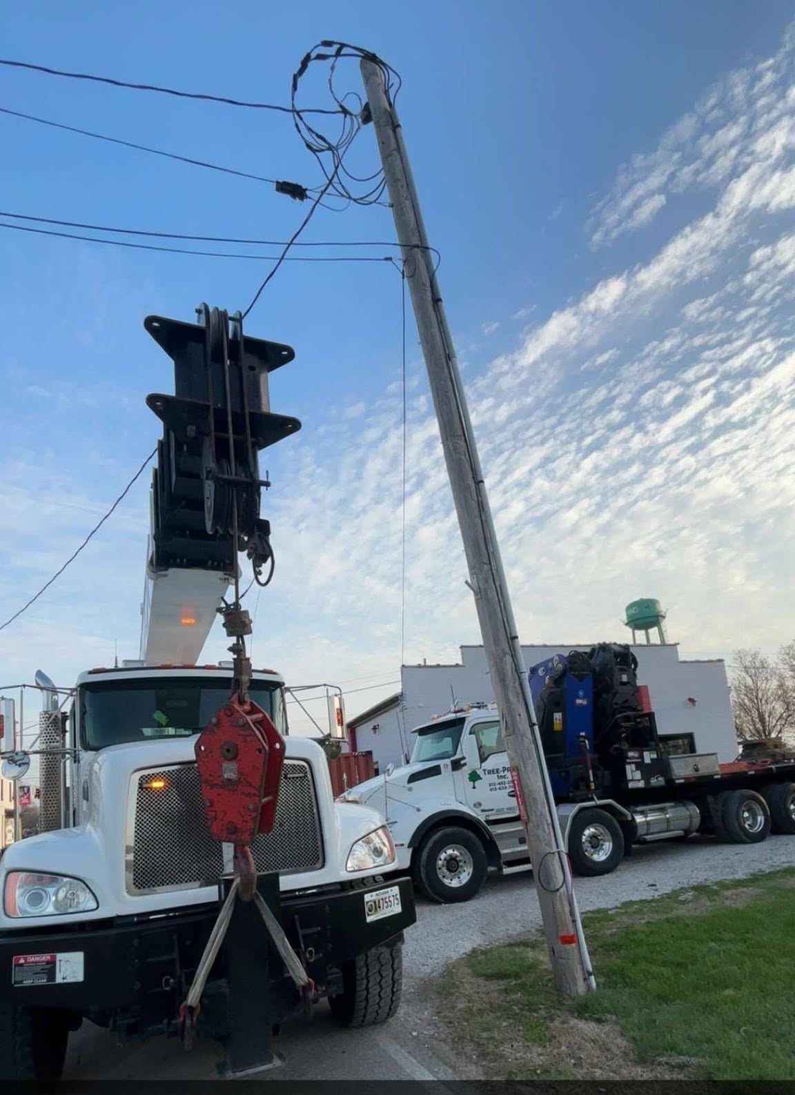 Two boom trucks lifting a heavy trunk section together